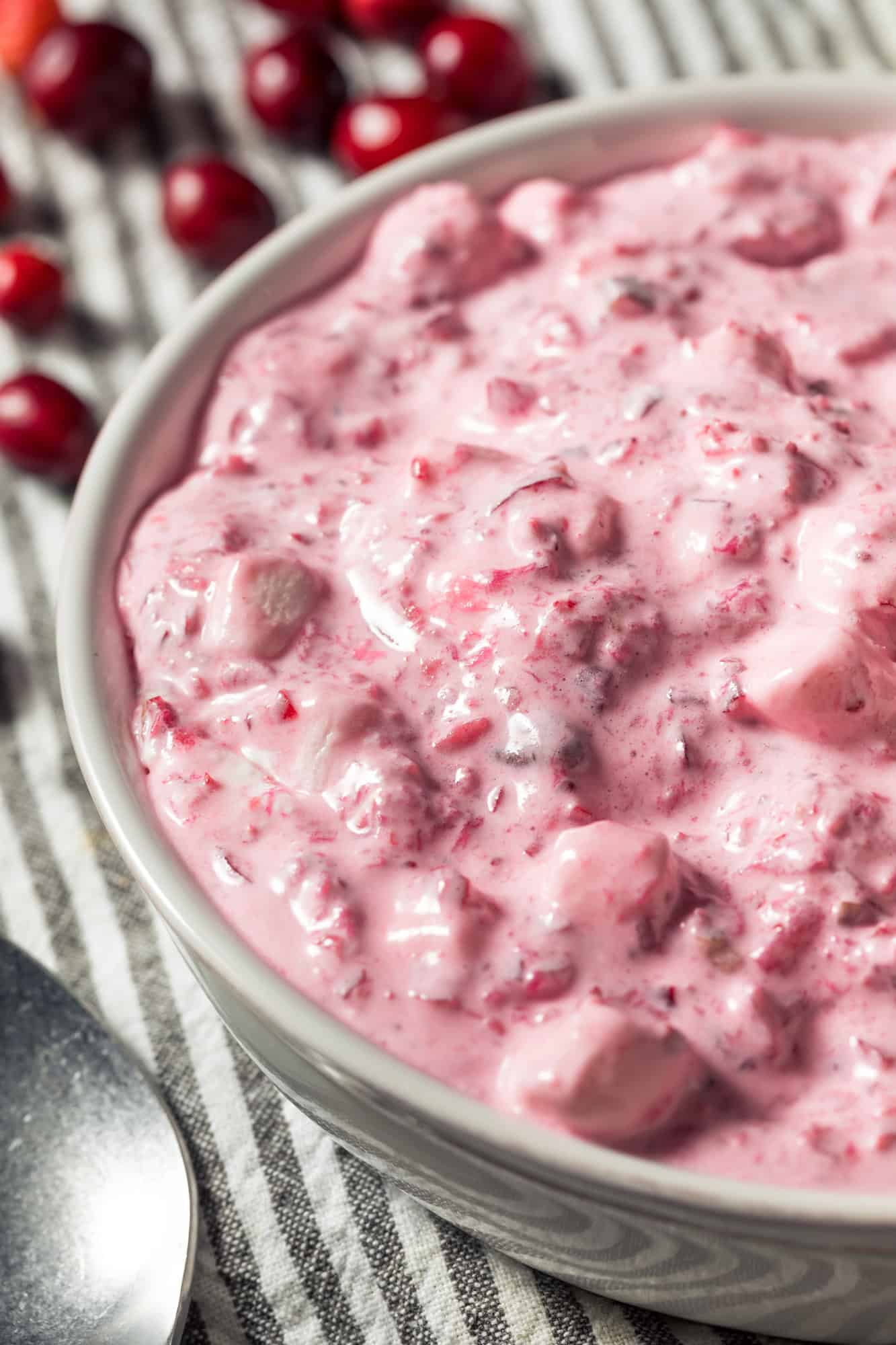 cranberry fluff salad recipe with canned cranberries and cool whip in a white bowl