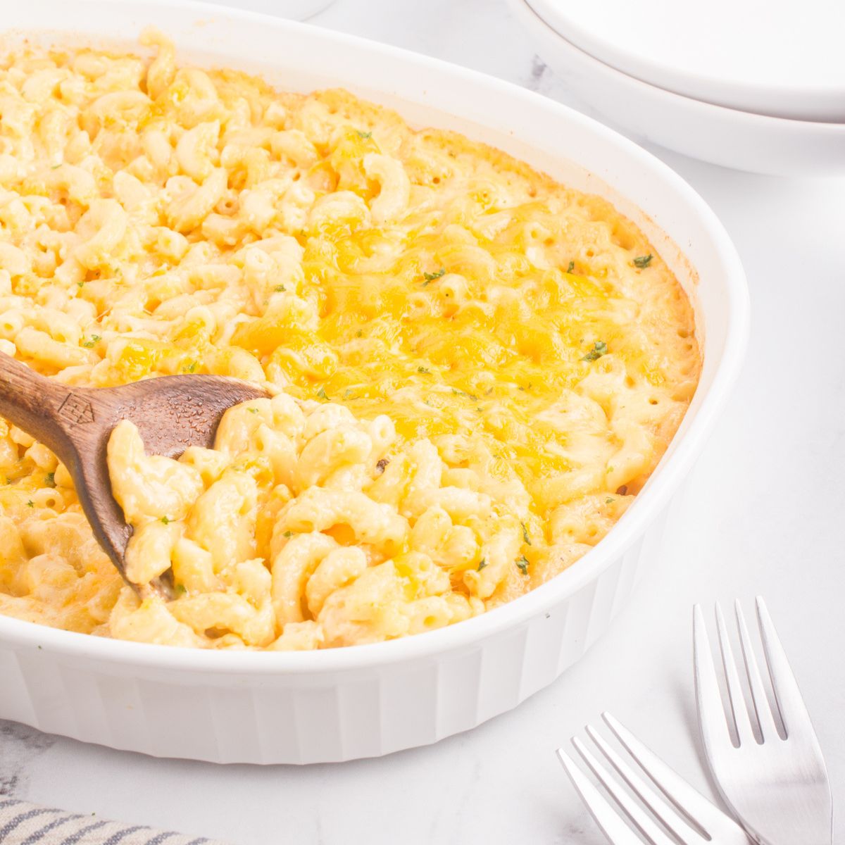 close up of old fashioned mac and cheese being spooned out of casserole dish