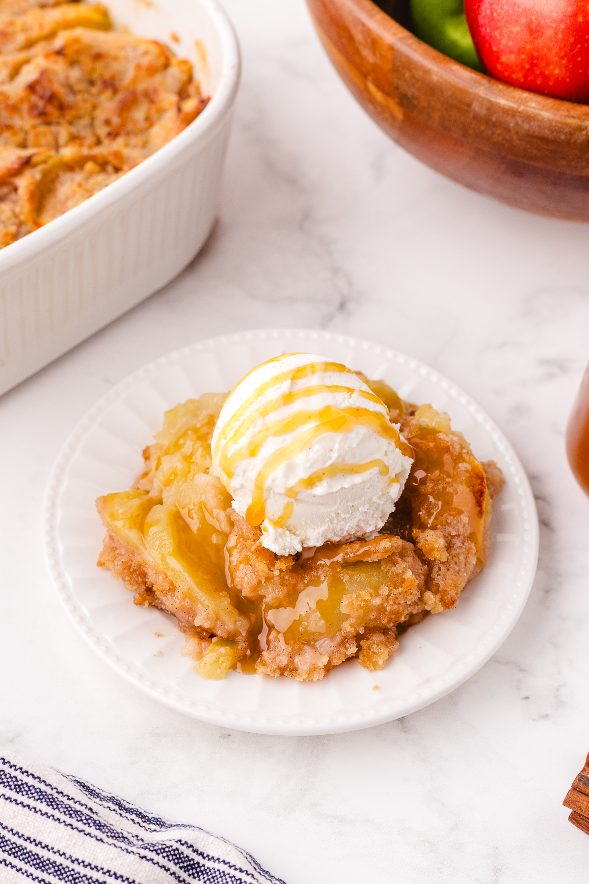 plate of old fashioned apple crisp being served with a scoop of ice cream on the top