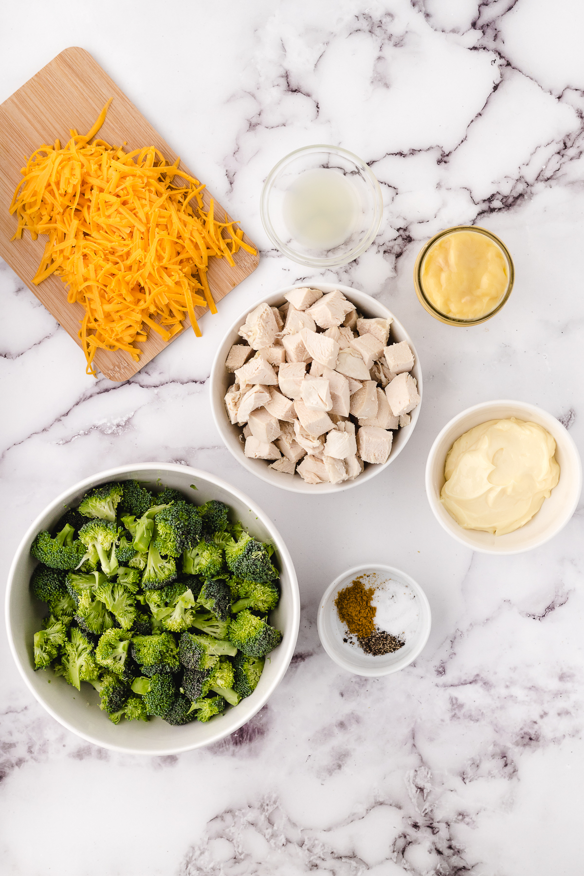 slow cooker chicken divan ingredients on a white marble cutting board