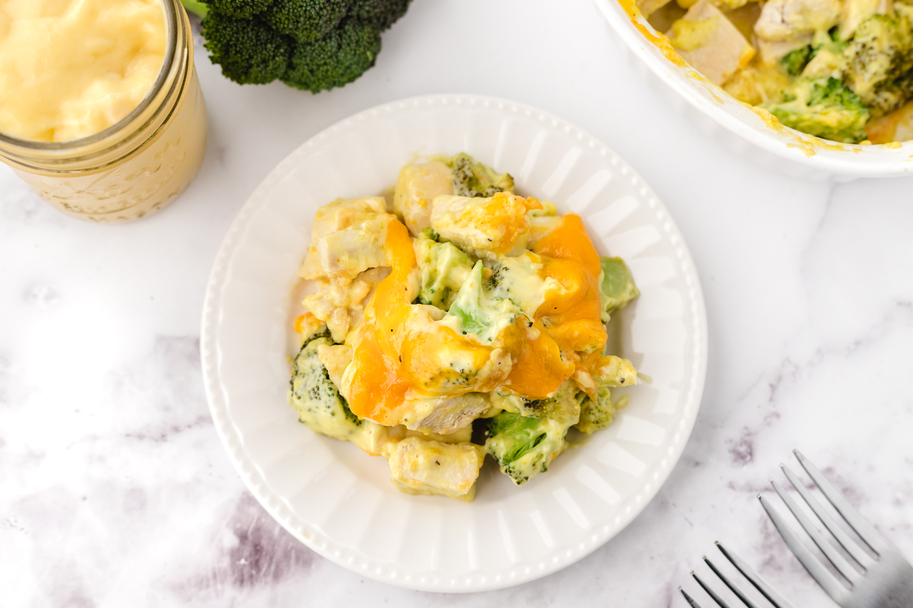 cheesy chicken divan casserole on a white plate before eating