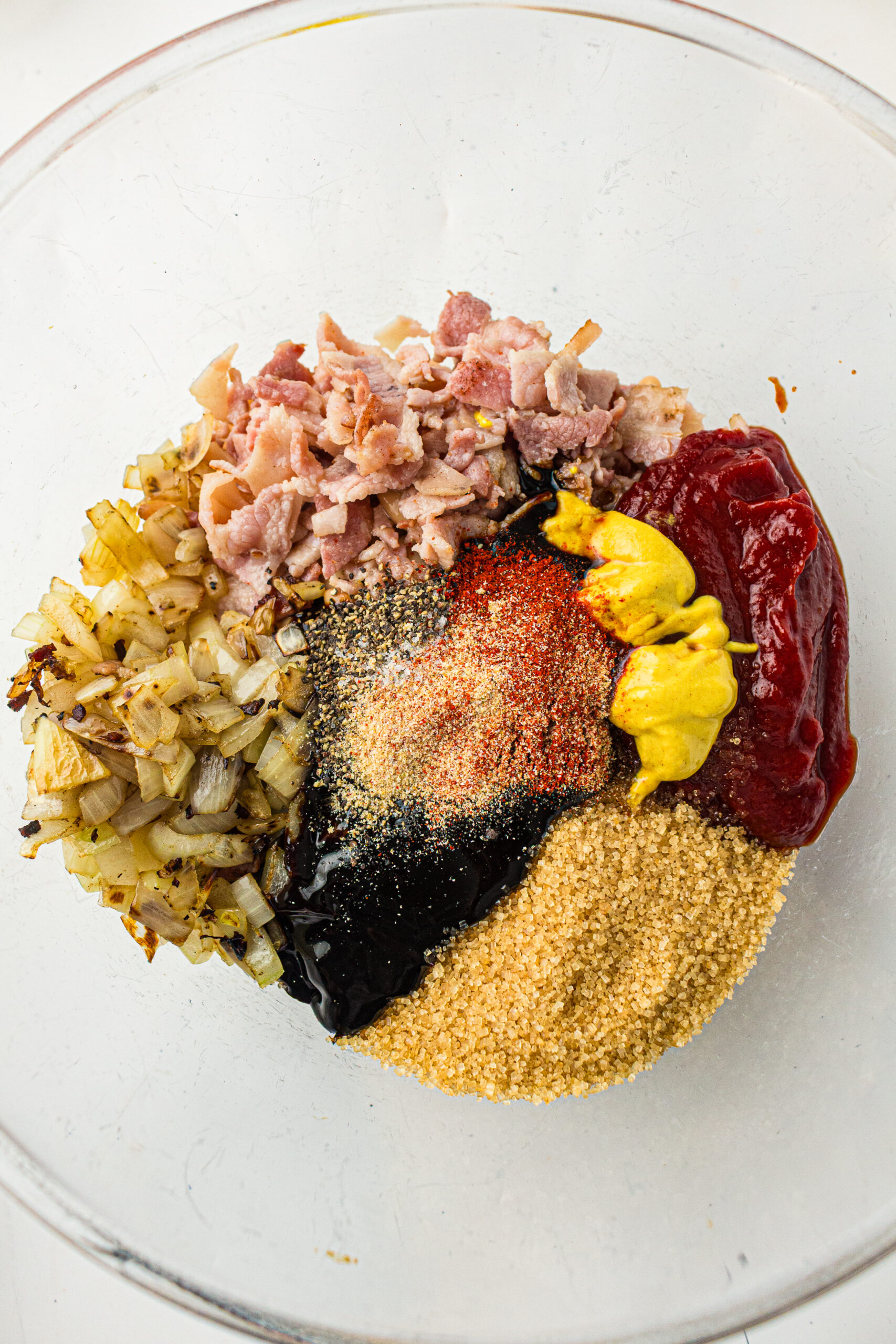 Cooked ingredients with seasoning for Southern baked beans.