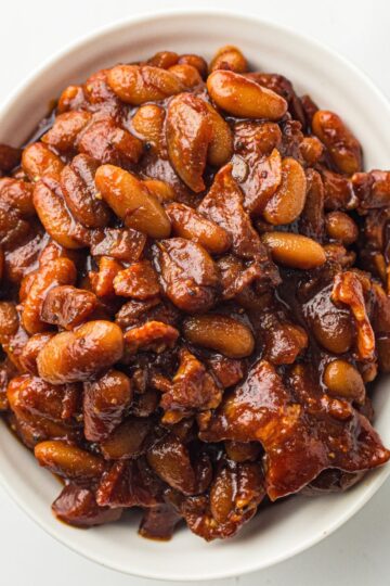 Old fashioned Southern baked beans being served in a white bowl.
