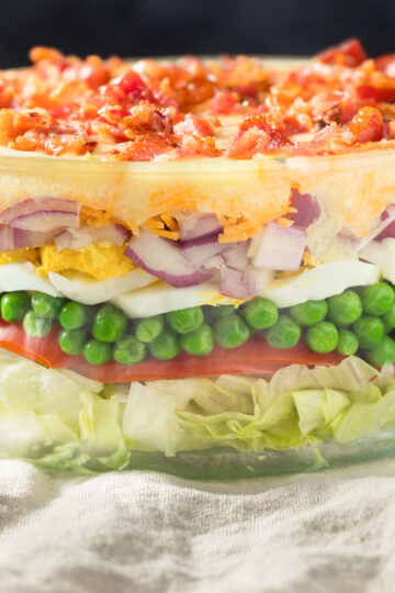 7 layer salad in a clear bowl being served
