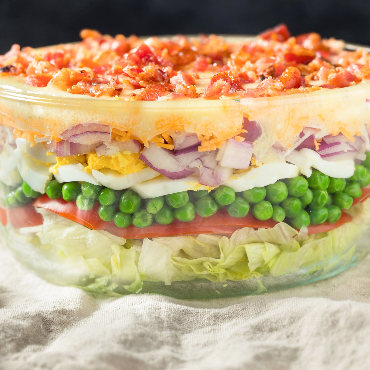 7 layer salad in a clear bowl being served
