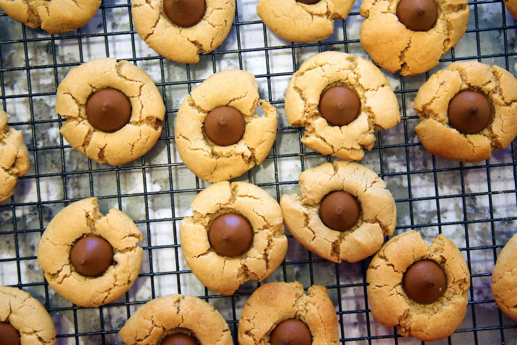 Close-up of peanut butter blossoms with cracked edges on a cooling rack