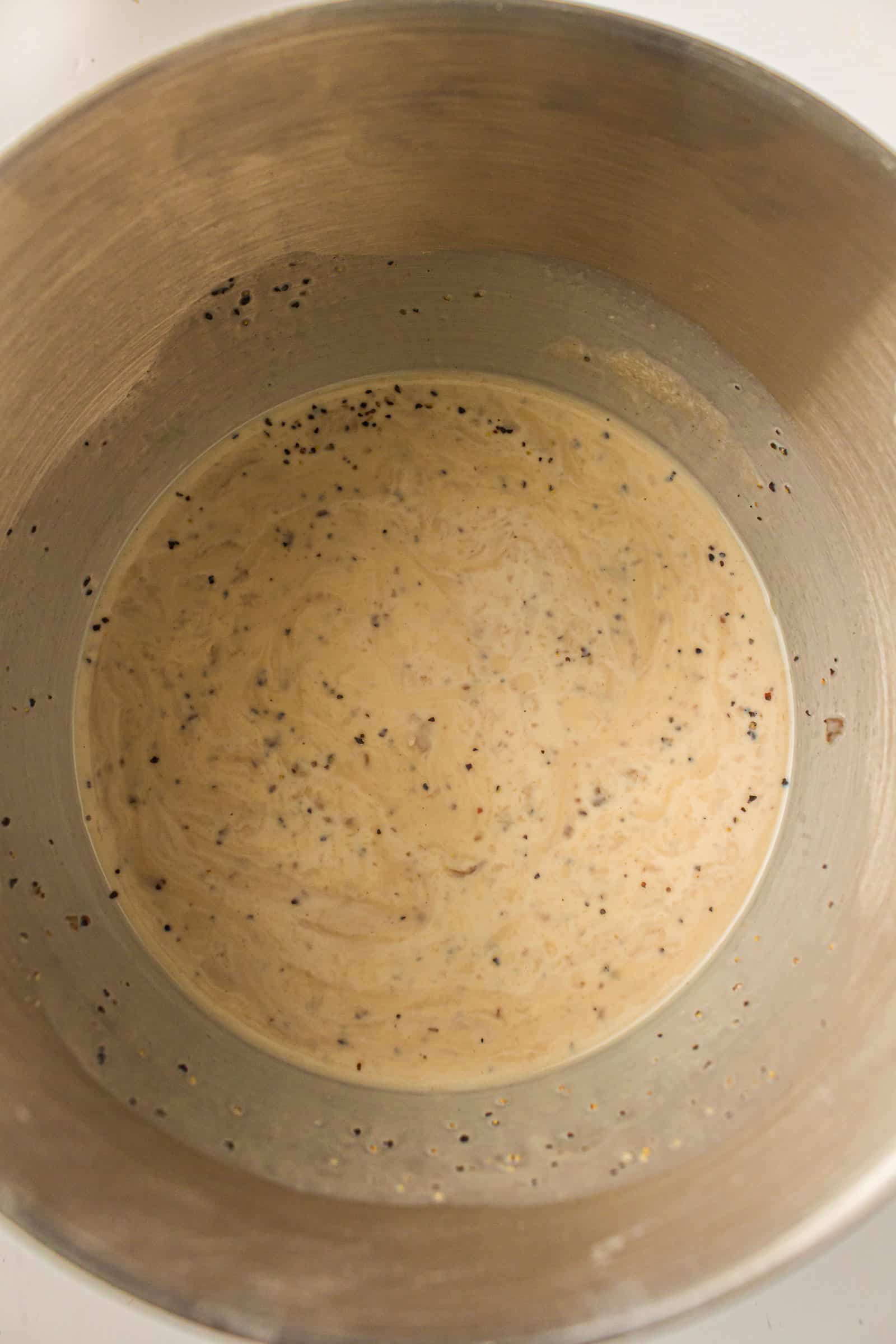 Cream of mushroom soup, milk and seasonings mixed in a bowl.