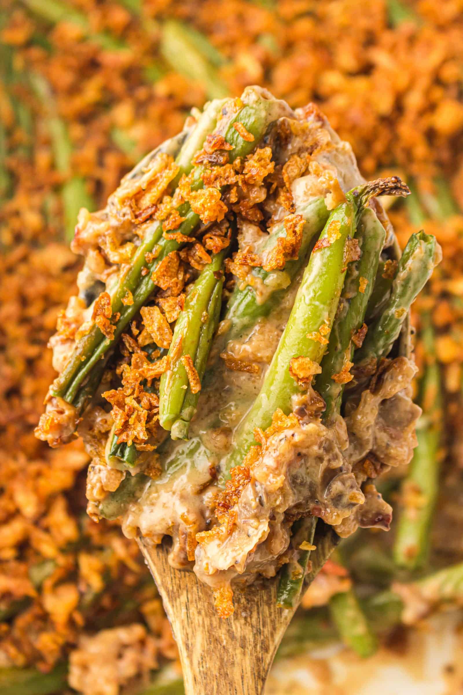 Spoonful of creamy green bean casserole with crispy onions.