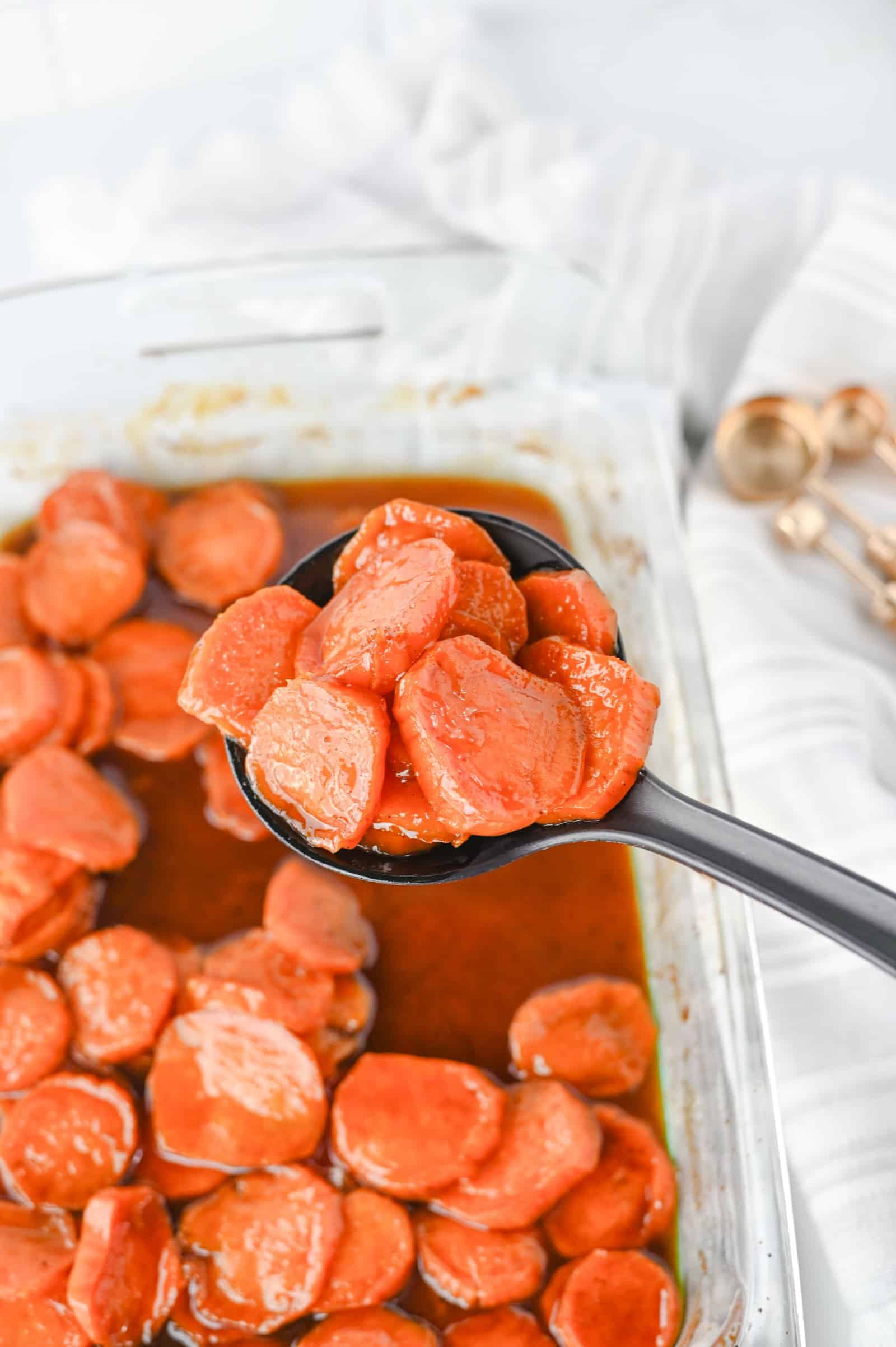 Spoonful of candied sweet potatoes lifted from the baking dish.