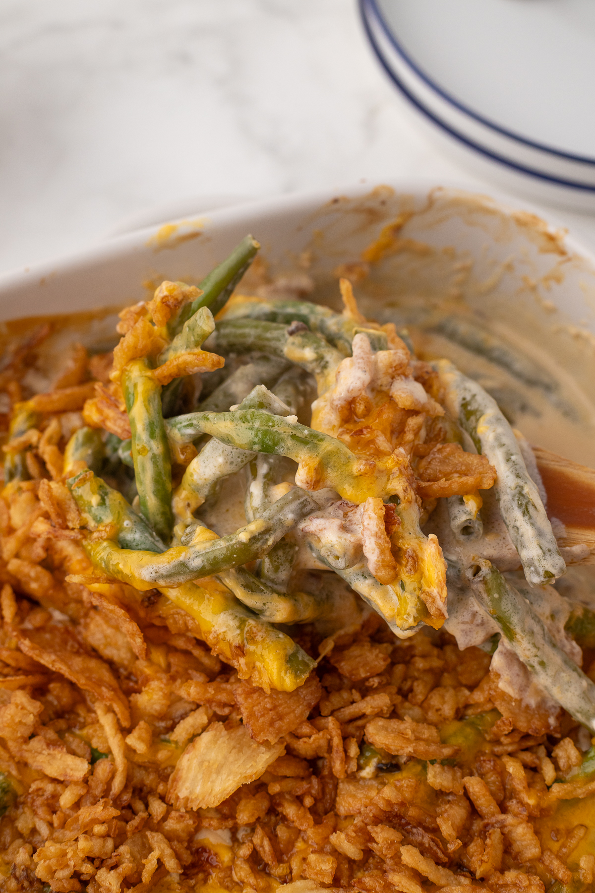 taking the green bean casserole out of the oven and scooping some onto a spoon