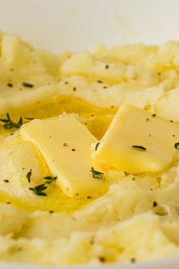 Old fashioned mashed potatoes topped with melting butter and fresh thyme.