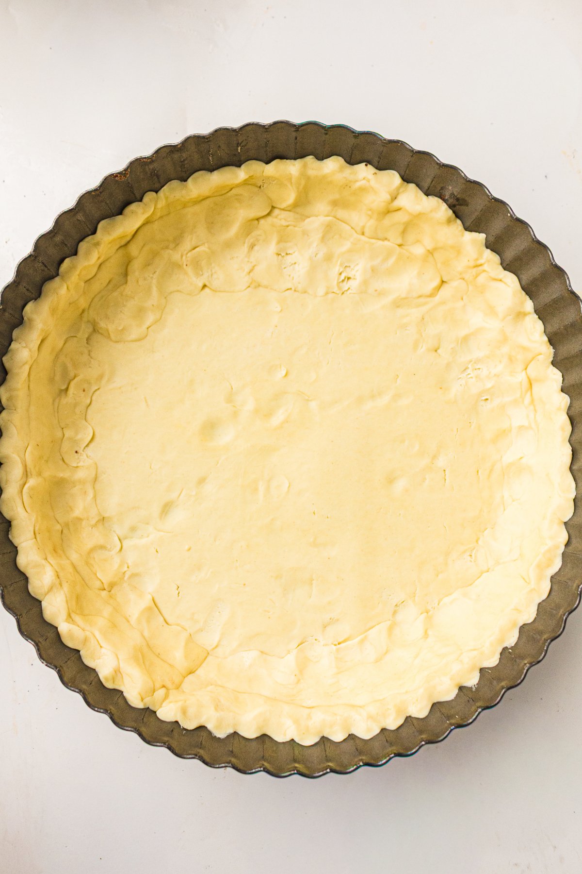 Unbaked pie crust fitted into a pie dish with crimped edges.