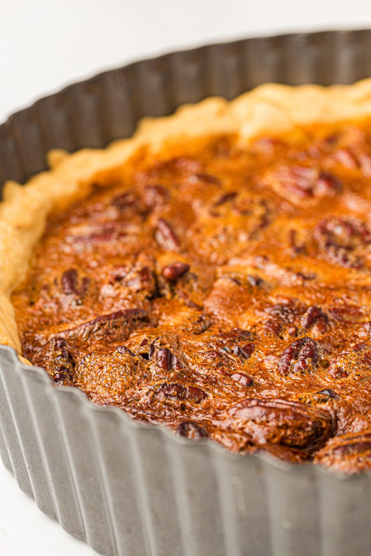 Whole baked old fashioned pecan pie cooling in a pie pan.