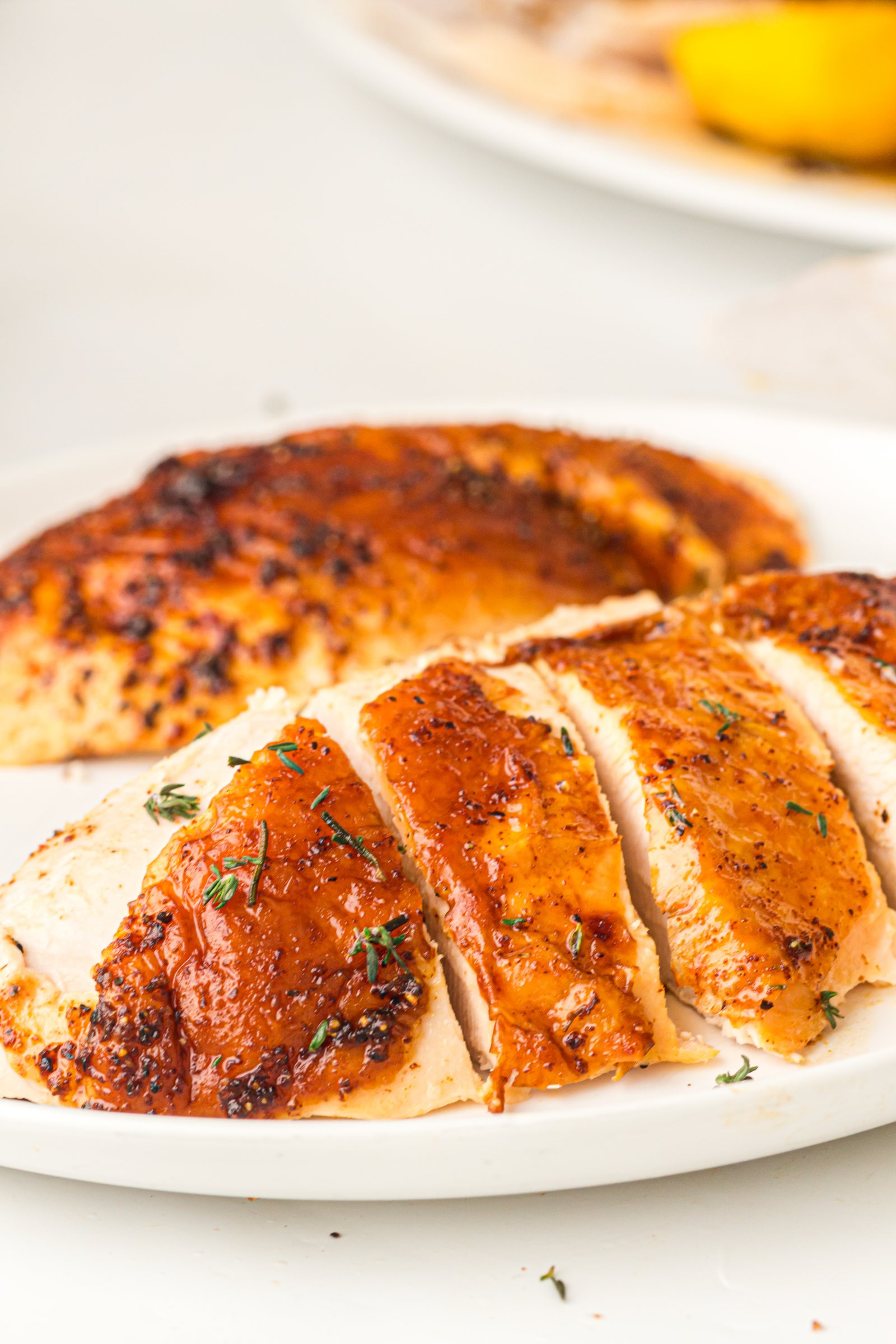 Sliced butter roasted turkey breast on a white platter.