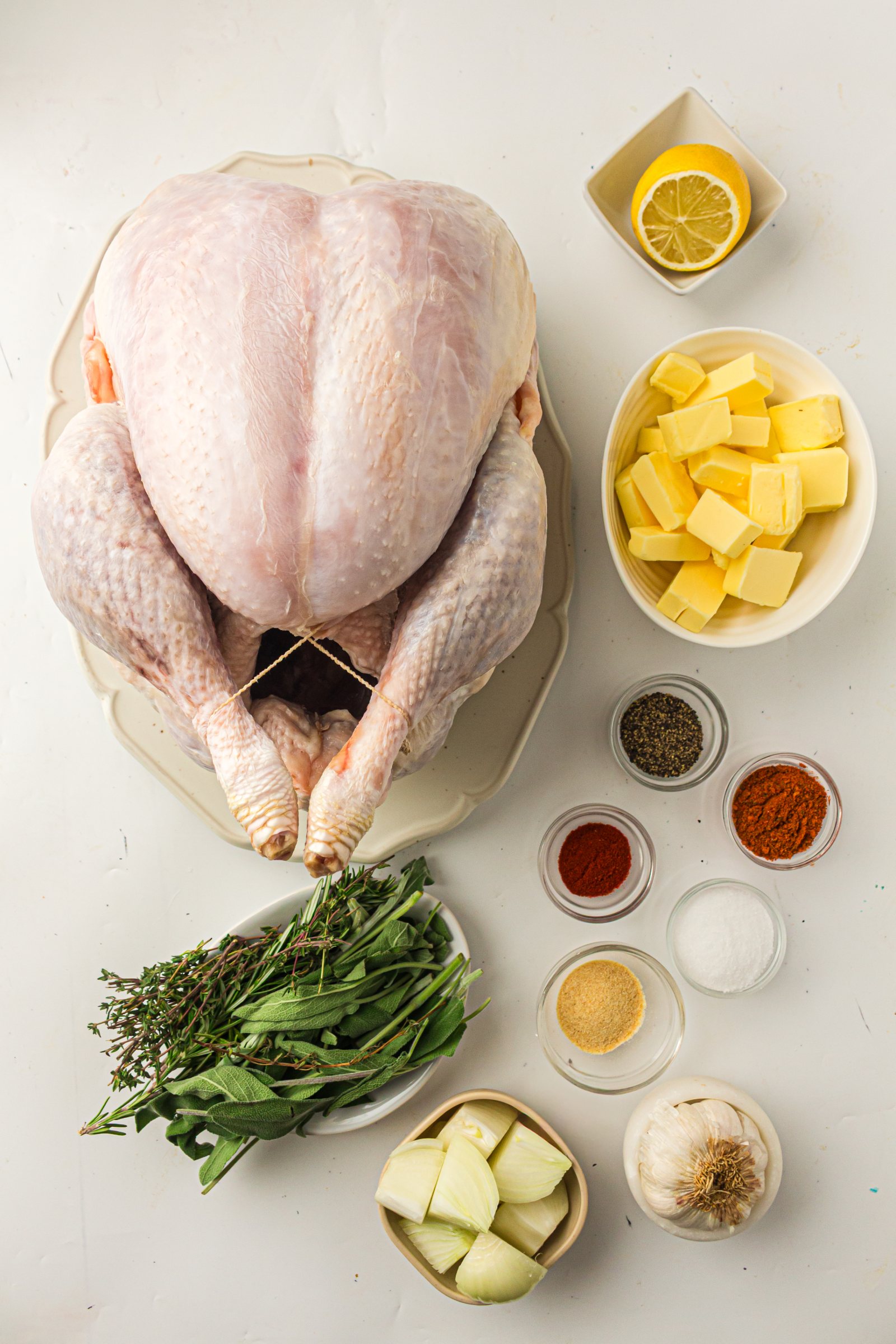 Ingredients for roast turkey with butter under the skin: whole turkey, butter, spices, lemon, garlic and herbs.
