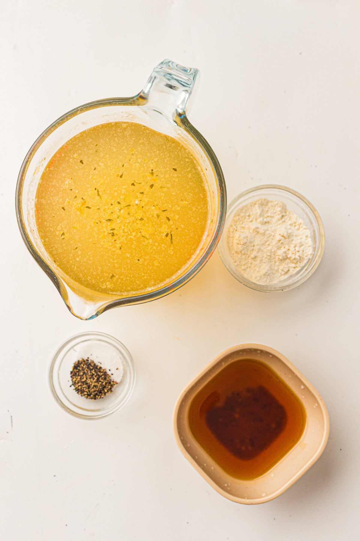 Ingredients for turkey gravy from drippings: broth, flour, turkey drippings and black pepper.