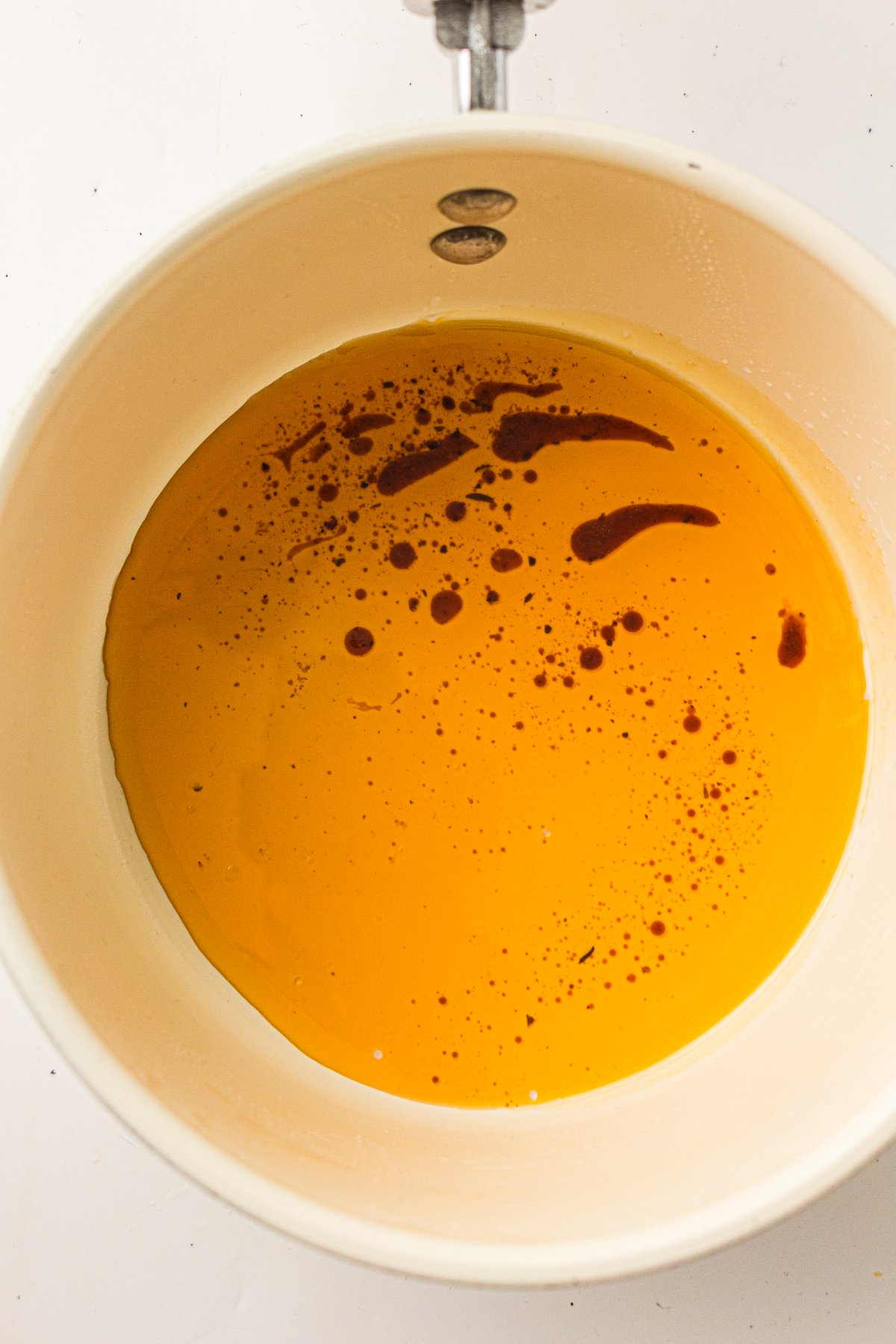 Turkey drippings heating in a saucepan.
